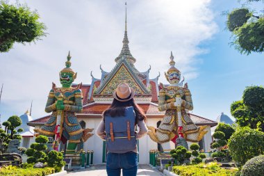 Asyalı kadın turist iki dev relax tatil sırasında ziyaret ediyor. Arun tapınakta landmark Bangkok, Tayland