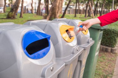 Kadınlar, çevre koruma ve atık ayrımının küresel ısınmayı azaltmasına yardımcı olmak için plastik şişeyi geri dönüşüm kutusuna atıyor