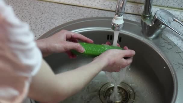 La chica lavando y enjuagando pepino fresco en la cocina — Vídeos de Stock