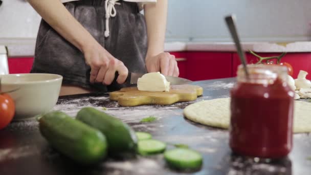Młoda dziewczyna wyciąć ser mozzarella na desce drewnianej — Wideo stockowe