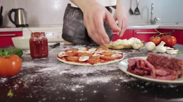 Hands of young girl put sausage on pizza dough — Stock Video