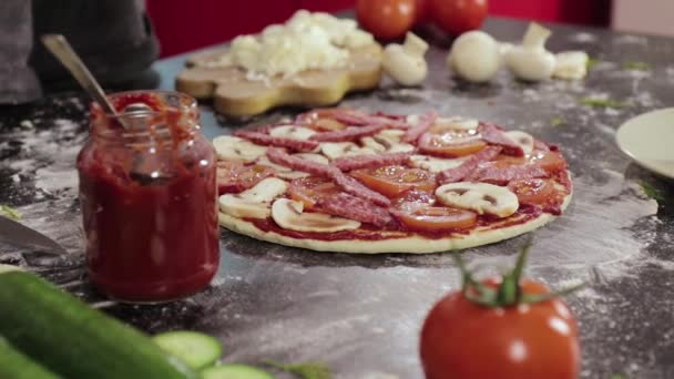 Hands of young girl put sausage on pizza dough in home — Stock Video