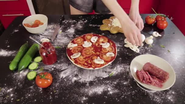 Hands of young girl put mushroom on pizza dough — Stock Video