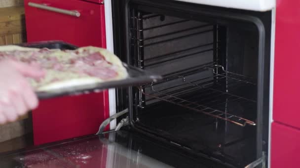 Sätt pizzan i ugnen och stäng henne. — Stockvideo