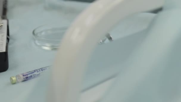 의사는 치과 기구를 씻어 내고 탁자 위에는 마취 된 주사기가 놓여 있습니다. — 비디오