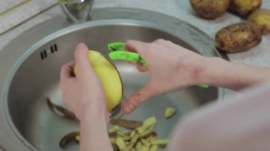 Eller patatesi lavaboda temizler. Yakın çekim.