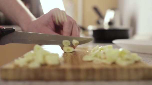 Kvinna skär vitlök på en trä skärbräda, sidovy — Stockvideo