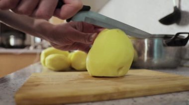 Eller tahtanın üzerinde patatesleri dilimlere ayırıyor. Yaklaş. 