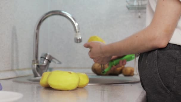 Руки почистити картоплю шкірки в раковині — стокове відео