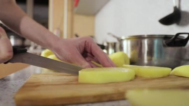 Eller patatesleri küçük dilimlere böler. 