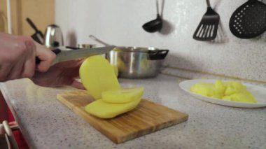 Eller tahta tahtada patatesleri dilimler.