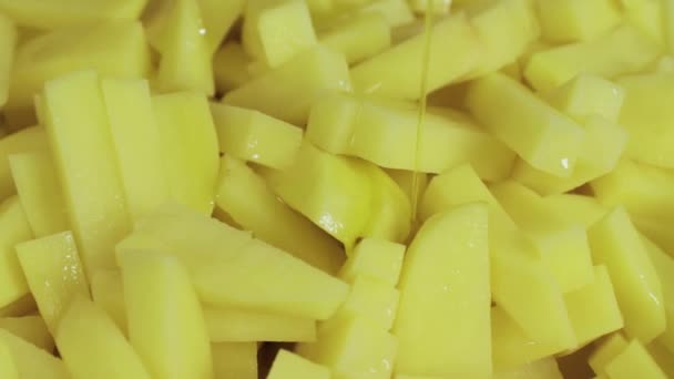 Olej se nalije na oloupané nasekané brambory zblízka — Stock video