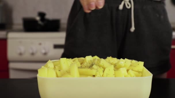 Девушка посыпает картофельный перец на домашней кухне — стоковое видео
