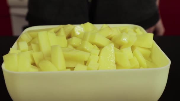 Масло выливается на очищенный картофель крупным планом — стоковое видео
