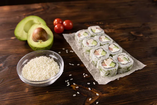 Avokado, domates, tavuk ve peynirli rulo siyah bir tahta üzerinde.