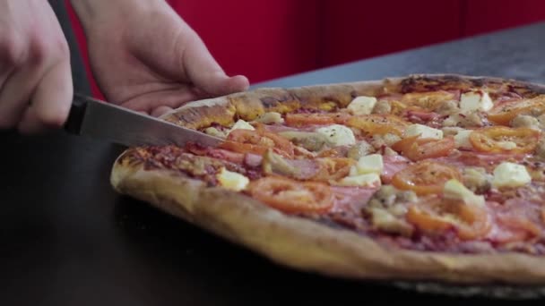 Mãos cortadas pizza queimada com carne e tomate na mesa preta de perto — Vídeo de Stock