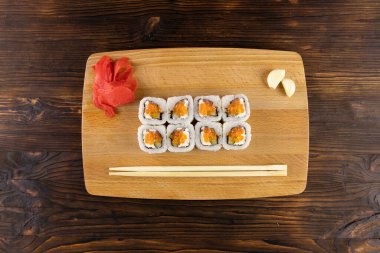 Somon balığı ve krem peynirli kırmızı havyar, zencefil, sarımsak, çubuklar ahşap tahta üstünde.