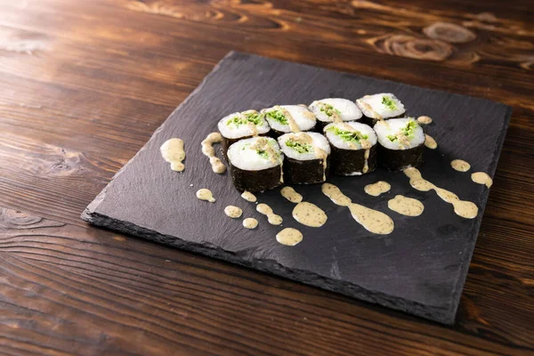 Chuka siyah Japon tabağında sos ile yuvarlanıyor.