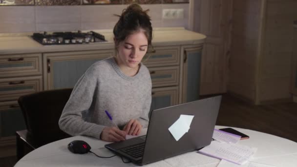 Jeune fille travailler sur ordinateur portable et se sentir mal au dos dans la cuisine à la maison — Video