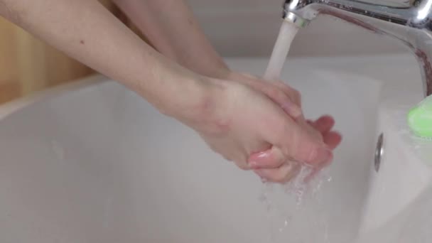 Handen van vrouw wast zeep van haar handen in de gootsteen — Stockvideo
