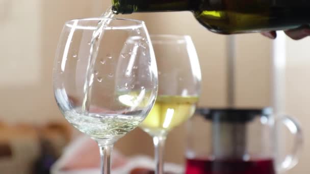 Fehér bort öntenek egy üvegből készült pohárba. — Stock videók