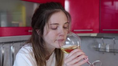 İşsiz kız mutfakta şarap içiyor.