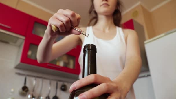 Girl in a white shirt is trying to open a bottle of wine — Stock Video