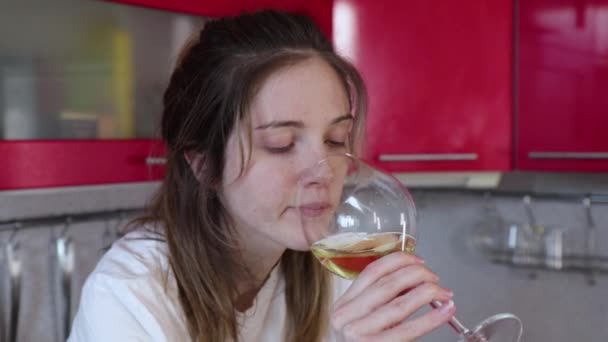 Безработная девушка пьет вино на кухне — стоковое видео