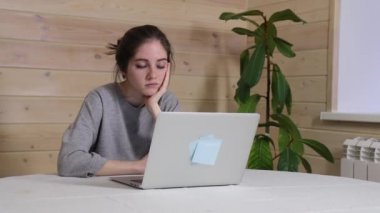 Dizüstü bilgisayarda çalışmaktan, şakaklara sürtünmekten bıkmış bir kadının baş ağrısı HD görüntüsü var.