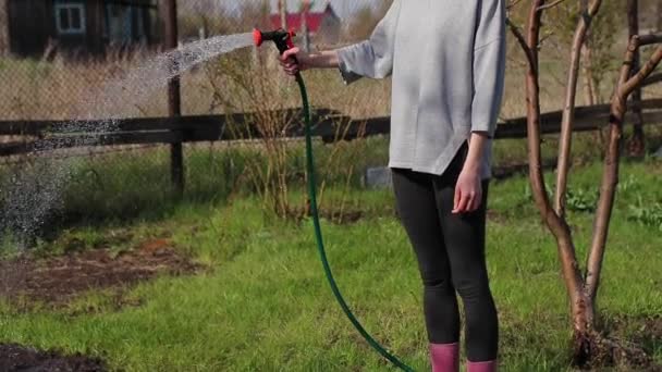 Young farmer girl watering garden beds with garden sprayer FHD — Stock Video