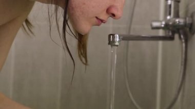 Genç kız banyo manzarasında yüzünü yıkıyor.