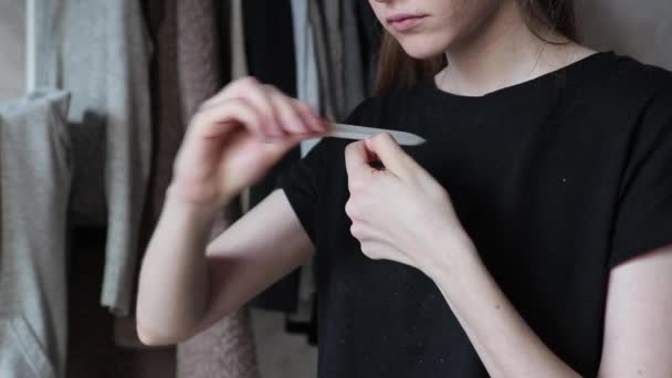 Woman cuts nails with nail file at home blurred background DIY medium shot — Stock Video