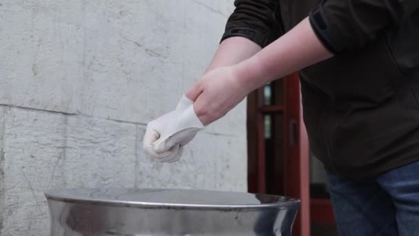 Man takes off rubber medical gloves and throws them in the trash — Stock Video