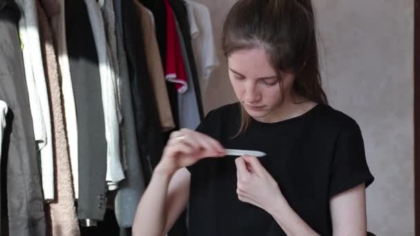 Женщина файлы ногтей с пилкой для ногтей на дому во время изоляции DIY — стоковое видео
