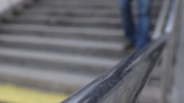 Lastik eldivenli adam merdivenlerden aşağı indi ve elini tırabzana attı. 