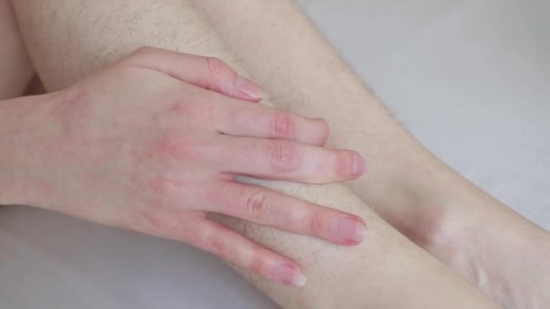 Ženy ruce hladí chlupaté nohy před depilací — Stock video