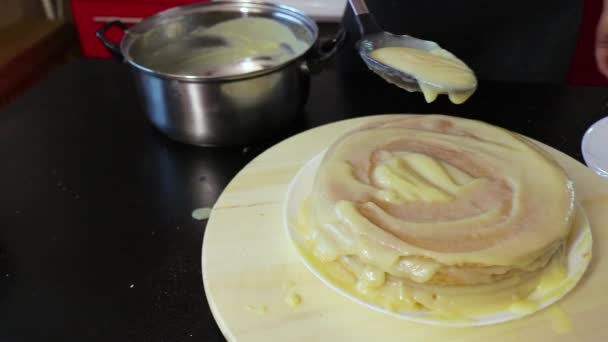 女人在圆圆的木制纺盘上的蛋糕上涂上抹布霜，相机就会移动 — 图库视频影像