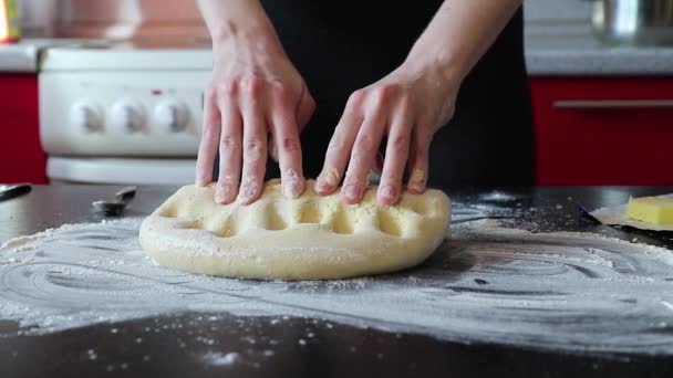 Женщина бьет тесто на столе и катит его — стоковое видео