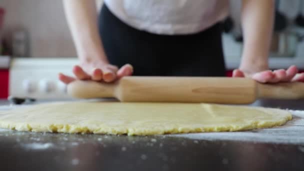 Kobieta toczy ciasto z wałkiem na stole — Wideo stockowe