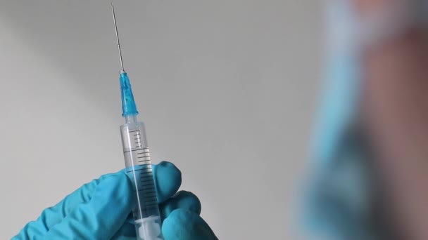 Arts handen houdt een spuit vast en bereidt zich voor om een injectie te geven — Stockvideo