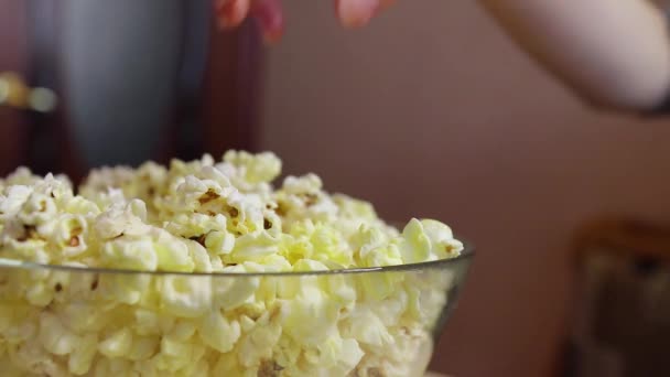 Hand neemt popcorn van een glazen plaat — Stockvideo