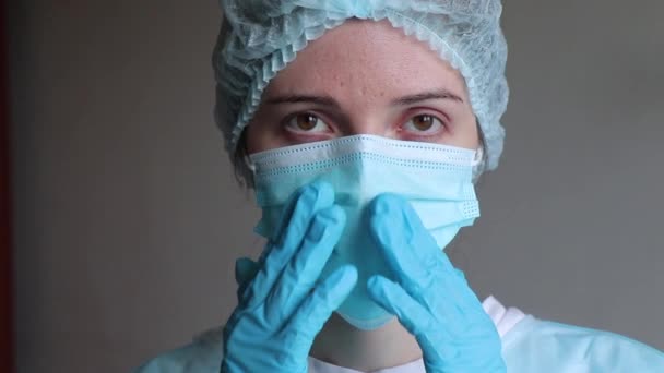 Médecin en gants de caoutchouc médical corrige un masque médical sur son visage — Video