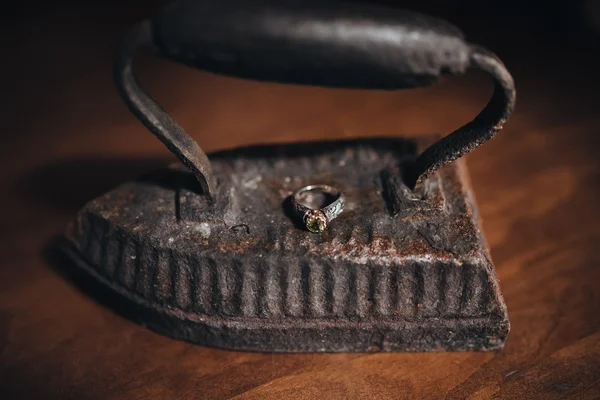 Wedding ring  lie on the vintage iron — Stock Photo, Image