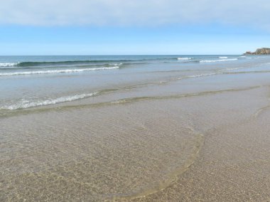 Temiz suları ve köpüklü kumları olan güzel bir sahil.