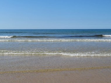 Temiz suları ve köpüklü kumları olan güzel bir sahil.