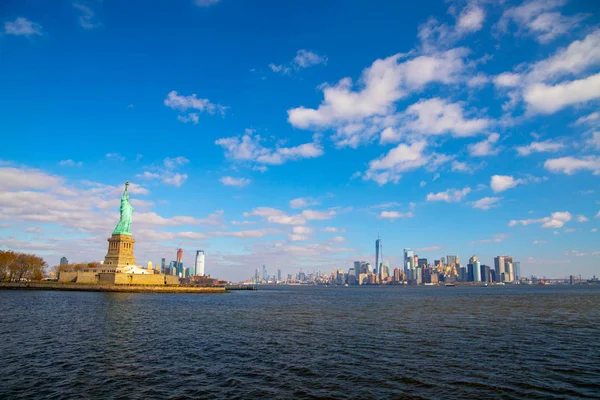 Statue of Liberty and New York Skyline isolated on the blue sky with white clouds. October 11,2018