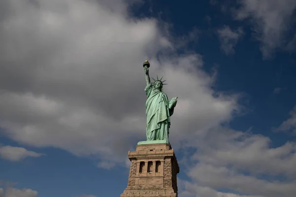 Güneşli bir günde, New York, Usa 'da mavi gökyüzünde beyaz bulutlarla izole edilmiş Özgürlük Heykeli. Ekim, 2018.