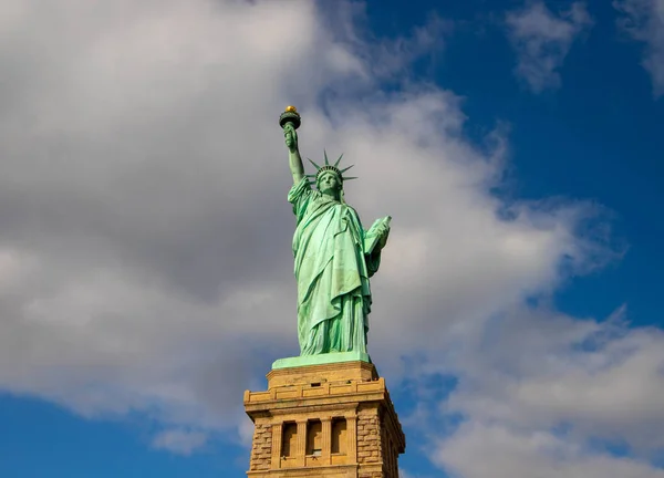 Güneşli bir günde, New York, Usa 'da mavi gökyüzünde beyaz bulutlarla izole edilmiş Özgürlük Heykeli. Ekim, 2018.