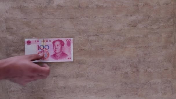 Hand Lässt Chinesische Währung Über Braunen Tisch Fallen — Stockvideo