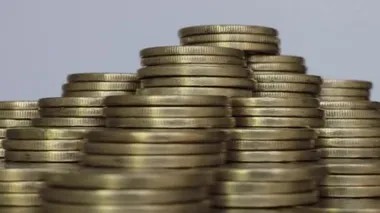 Altın sikkeler beyaz arkaplan üzerinde kümeler halinde dönüyor